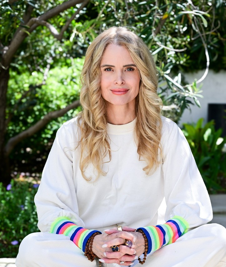 Jennifer Leigh sitting in a sunlit garden, smiling